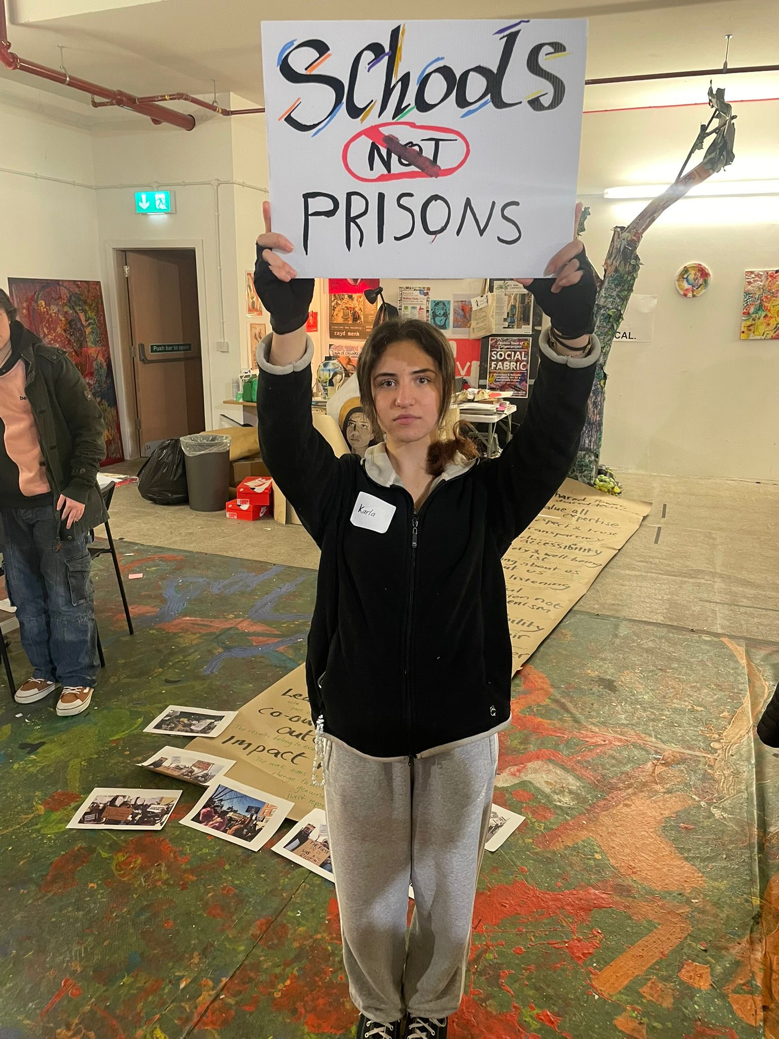 Young participant holding a Schools not prisons statement during an England youth session